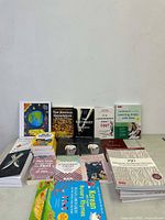 Lot of 16 new books displayed against a white wall including titles on language learning, psychology, and novels.