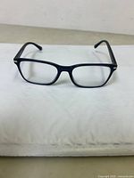 Front view of Prada rectangular optical glasses with clear lenses on a white surface.