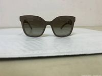 Front view of Prada SPR24Q TFT4M1 sunglasses showing square dark gradient lenses and frame shape.