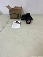 Box labeled 'HEADLIGHT LONG SHOT' alongside the headlamp and user manual laid out on a table.