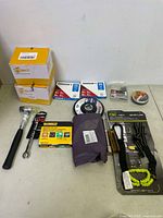 Photo of all tools and accessories arranged on the floor including tools, lanyards, boxes, and grinding wheels.