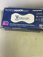 Close-up of single box labeled Royal Touch 300, containing 300 non-sterile nitrile examination gloves in medium size