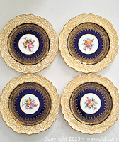 Four antique George Jones & Sons cabinet plates arranged in a square, showing their scalloped gilt floral borders and cobalt blue centers with floral bouquets.