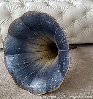 Front view of antique phonograph horn showing flared blue-painted bell shape with visible scratches and age-related wear.