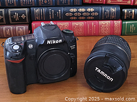 Nikon D80 camera body and Tamron lens side by side on a wooden surface with books in the background.