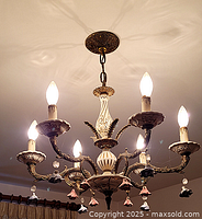 Full view of chandelier hanging with all six bulbs illuminated