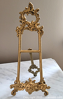 Full view of the gilt metal easel showing the overall design and height.
