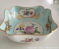 Full top angled view revealing floral pattern, gold edging, and light blue interior background.