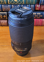 Lens standing upright showing front view with Nikon lens cap