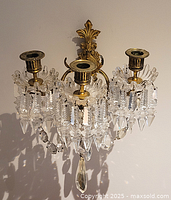 Front view of both brass crystal wall sconces mounted side by side