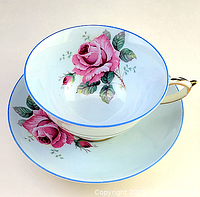 Side view of Paragon teacup and saucer showing floral pattern and gold handle detail