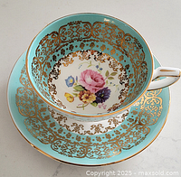 Teacup and saucer front side showing floral design and gold pattern