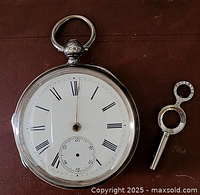 Front view of the pocket watch with white enamel dial, roman numerals, small seconds dial, missing minute hand, and accompanying winding key.