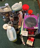 All car maintenance and accessory items arranged, including fluids, sprays, multi tester, trailer light kit, and bungee cords.