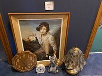 Photo of wall art, wooden octagonal clock, white alarm clock, cat solar light, and floral glass lamp grouped together.