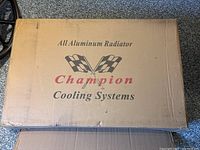 Closed cardboard box with “All Aluminum Radiator Champion Cooling Systems” printed