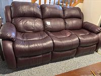 Frontal view of burgundy leather three-seat recliner sofa