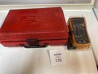 Red molded Snap-on carrying case and Fluke meter in protective plastic bag on white surface