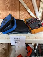 Photo with yellow RMS multimeter and two carrying cases on a shelf