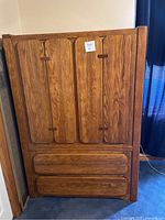 Front view of the wooden wardrobe showing the four drawers and wood grain finish.