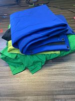 Folded blue, green, and black backdrop cloths stacked