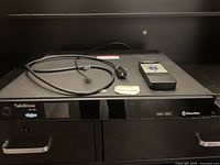 Front view of NewTek TalkShow VS-100 unit with power cord and remote on top, showing branding and model details.