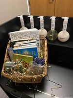 Gift basket filled with self-help books, candles, sage, and Nature Lab shampoo and conditioner bottles.