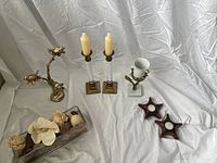 Overview of all items arranged on white cloth background including towel holder, cup holder, two candle holders with candles, wooden star-shaped candle holders, and glass potpourri container.