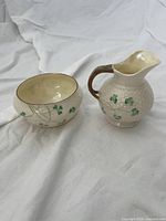 Two-piece Beleek Ireland cream and sugar set with shamrock design on white bone china, cream pitcher with handle and sugar bowl.
