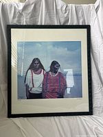 Full view of the framed art print showing two Native American women and black wooden frame.