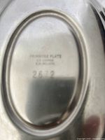 Close-up image of maker's mark and inscription on underside of gravy boat or stand showing 'PRIMROSE PLATE' and other markings