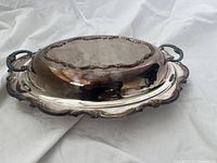 Silver-plated serving dish with lid, showing tarnished bottom and one handle.