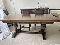 Full view of table showing overall shape, top, apron carving, and base