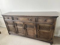 Full front view of the buffet showing three top drawers and four lower doors.