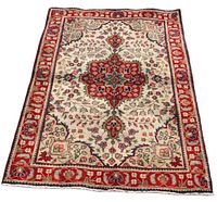 Full view of rectangular Tabriz rug with ivory field, red border, central medallion and floral motifs