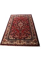 Full view of Kashan Persian handmade wool rug showing red central medallion and intricate border design.