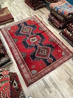 Full view of red geometric Persian rug laid flat on floor