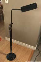 Adjustable black floor lamp with metal rectangular shade shown from different angles