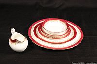 Partial Aynsley place setting arranged showing gravy boat and nested plates and bowl