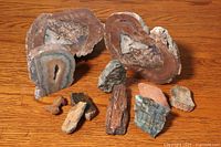 Overview of all seven rock specimens arranged on wooden surface, showing variety in size, texture, and color