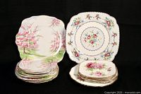 Full view of stacked mixed Royal Albert plates from three different collections, showing floral and landscape designs.