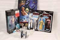 Star Wars memorabilia including boxed Obi-Wan Kenobi figure, two vintage style Last Jedi figures, Star Wars puzzle, and four loose ships in front.