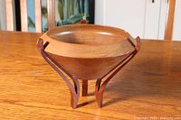 Artist turned wooden bowl resting on table showing overall shape and stand structure.