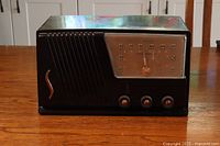 Front view of the vintage black Silvertone radio showing the speaker grill, control knobs, and frequency dial.