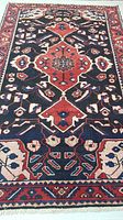Full view of the Mahal Persian rug showing the main medallion and dark blue background with borders.