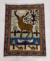 Full view of Ardebil Persian rug showing central deer motif, birds, trees, and border design.