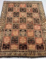 Full view of rectangular rug with panel grid of abstract tribal motifs