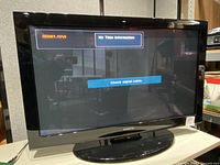 Front view of the Samsung TV powered on, showing 'No Time Information' and 'Check signal cable' on screen.