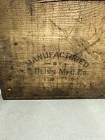 Close-up of manufacturer's stamp on wood: 'Manufactured by R. Bliss Mfg. Co.'