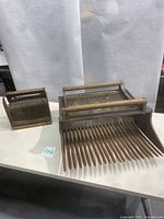 Photo showing both the large cranberry rake and small blueberry rake side by side on a table, background white paper